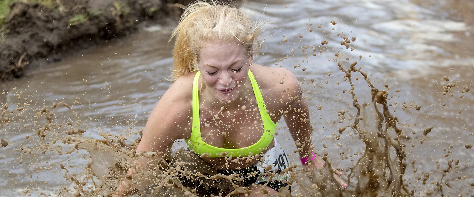 Woman Splashing in Mud Obstacle