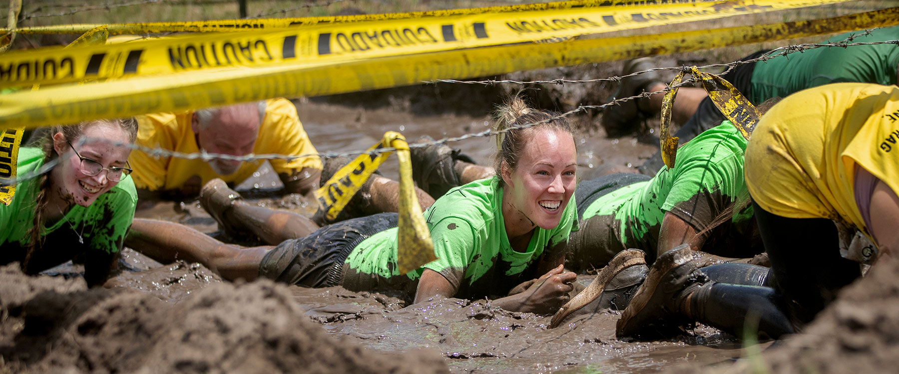 Woman Crawling in Mud Under Barbed Wire