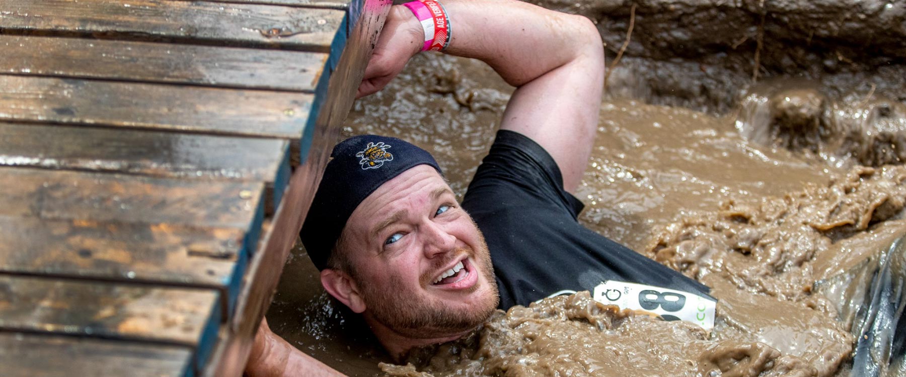 Man Dragging Himself Through a Muddy Obstacle